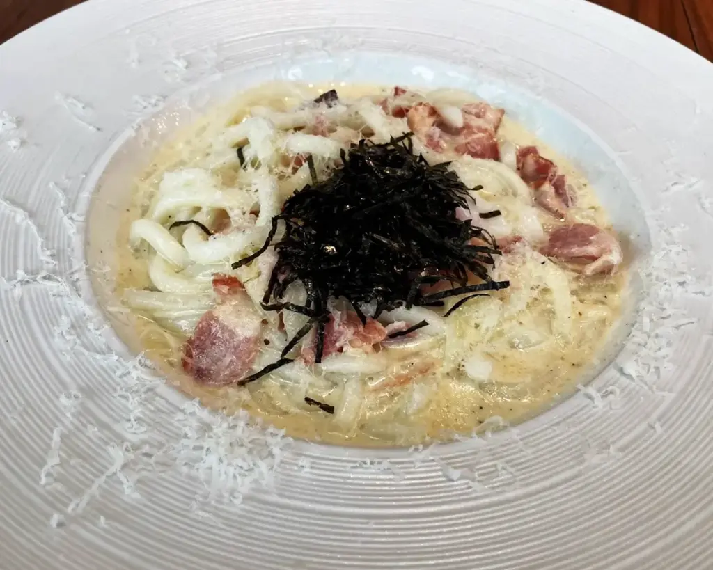 A plate of creamy pasta infused with truffle flavour, finished with a smooth sauce and elegant garnish for a rich and luxurious taste.