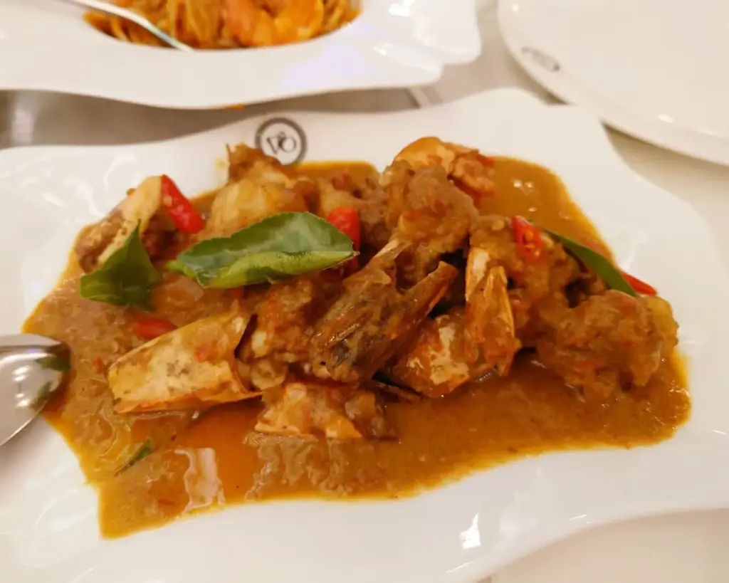 Crispy fried prawns coated in a glossy, spicy chilli sauce, served hot with a rich aroma and vibrant red tones that highlight its bold flavour.