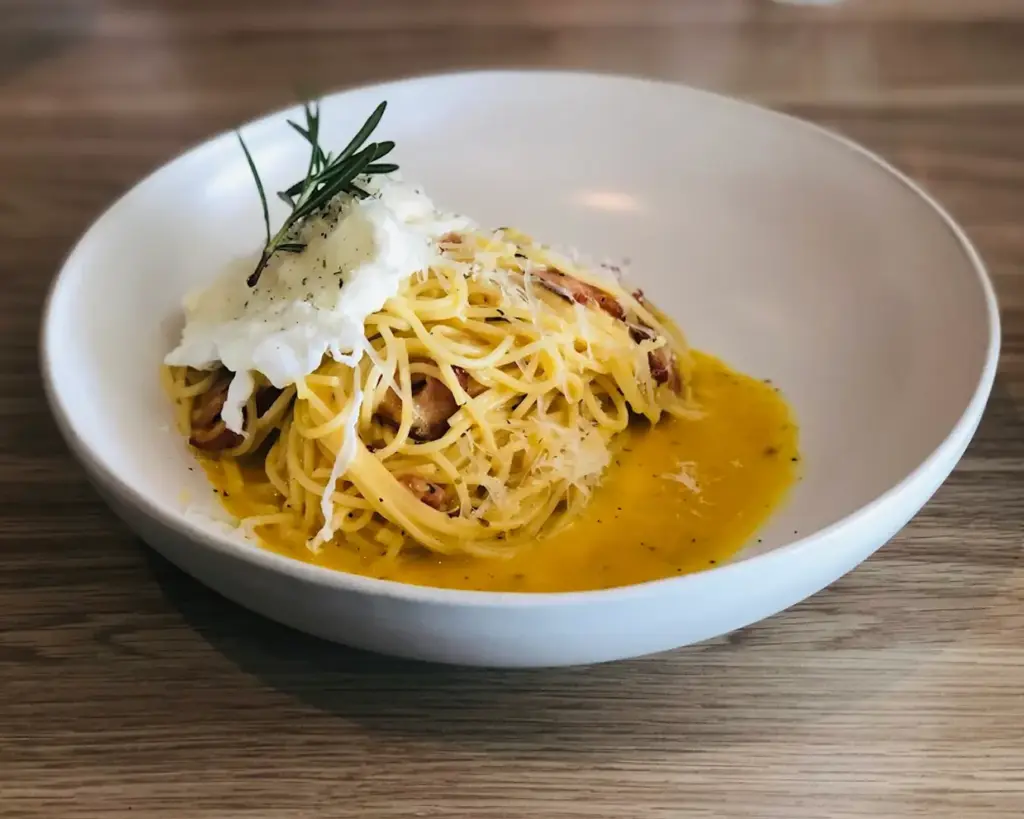 A plate of pasta tossed in a spicy, savoury sauce with generous chunks of crabmeat, garnished with herbs for a rich and indulgent seafood dish.