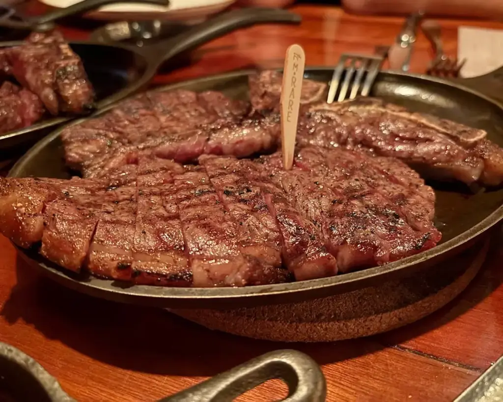 High-quality steak cuts with marbling, grilled to perfection, showcasing juicy texture and rich flavour on a clean, minimal plate.
