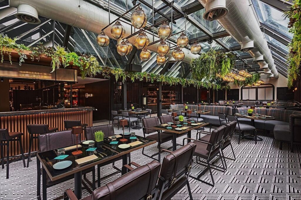 A view of the restaurant at the hotel on Orchard Road, showcasing its elegant glass roof design.