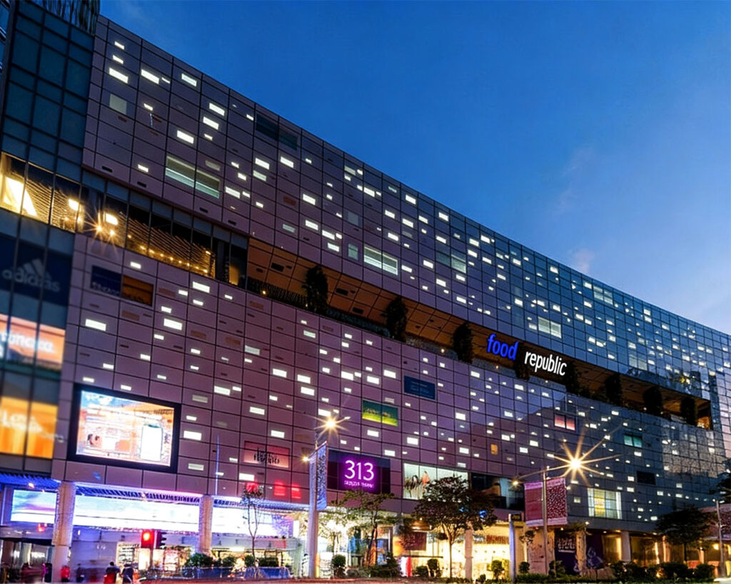 Exterior view of 313 Somerset mall along Orchard Road, showing its modern glass façade, digital signage, and bustling city surroundings in Singapore’s prime shopping district.