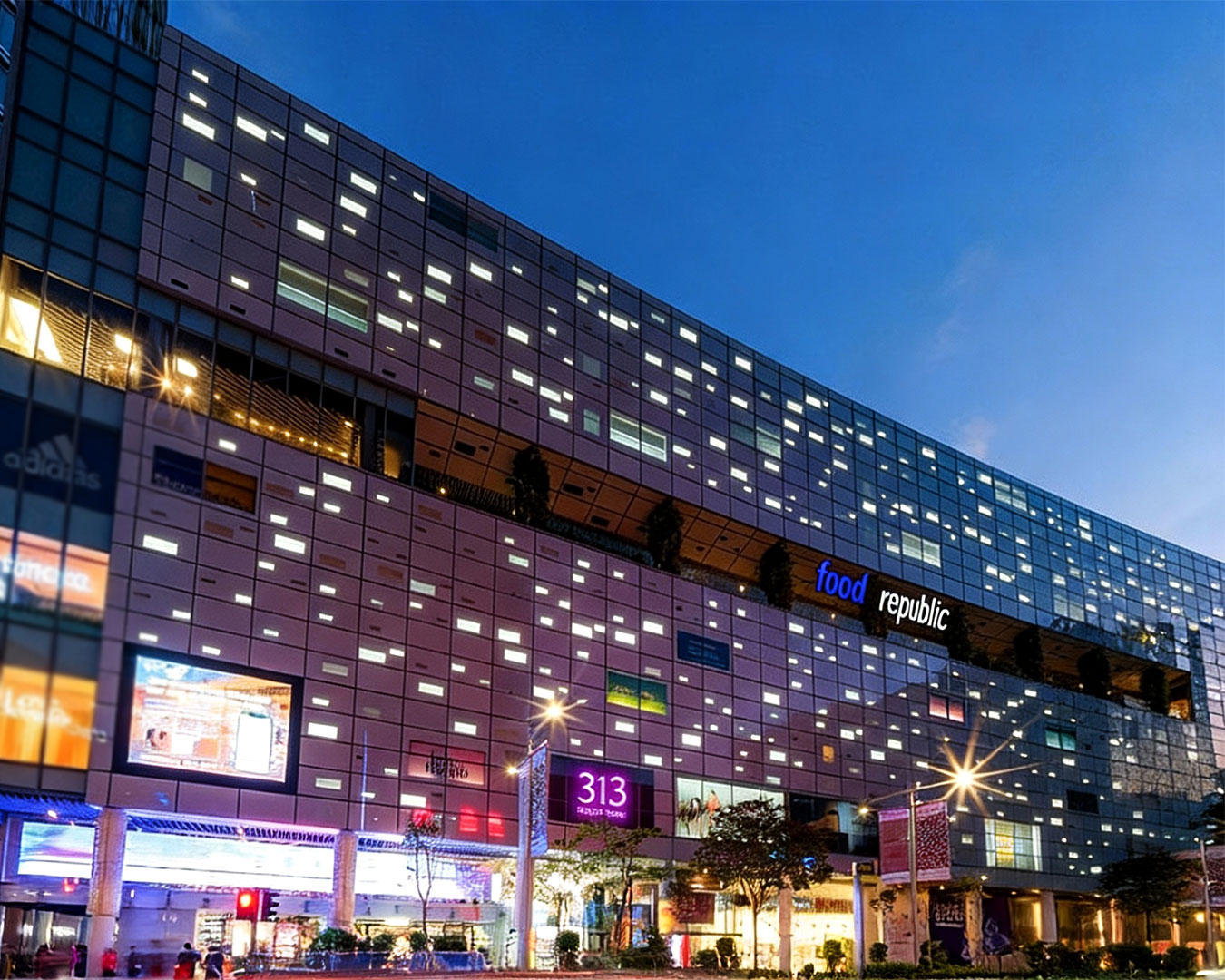 Exterior view of 313 Somerset mall along Orchard Road, showing its modern glass façade, digital signage, and bustling city surroundings in Singapore’s prime shopping district.