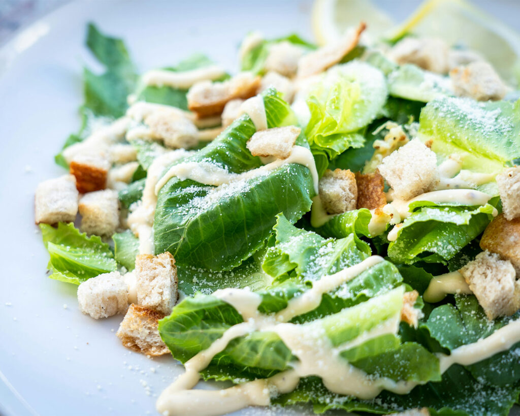 A fresh and colourful salad served on a plate, featuring crisp greens, cherry tomatoes, and other vegetables, looking healthy and appetising.