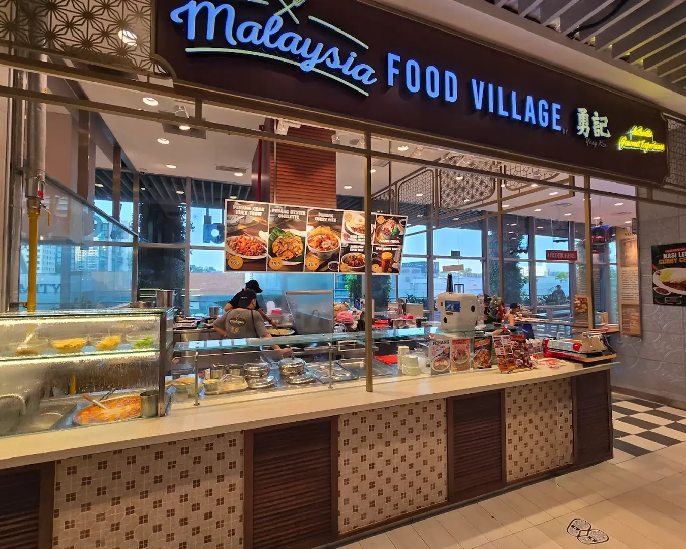 Interior of a casual dining restaurant inside 313@Somerset Orchard mall, featuring contemporary warm lighting, and customers enjoying meals in a lively shopping mall environment.