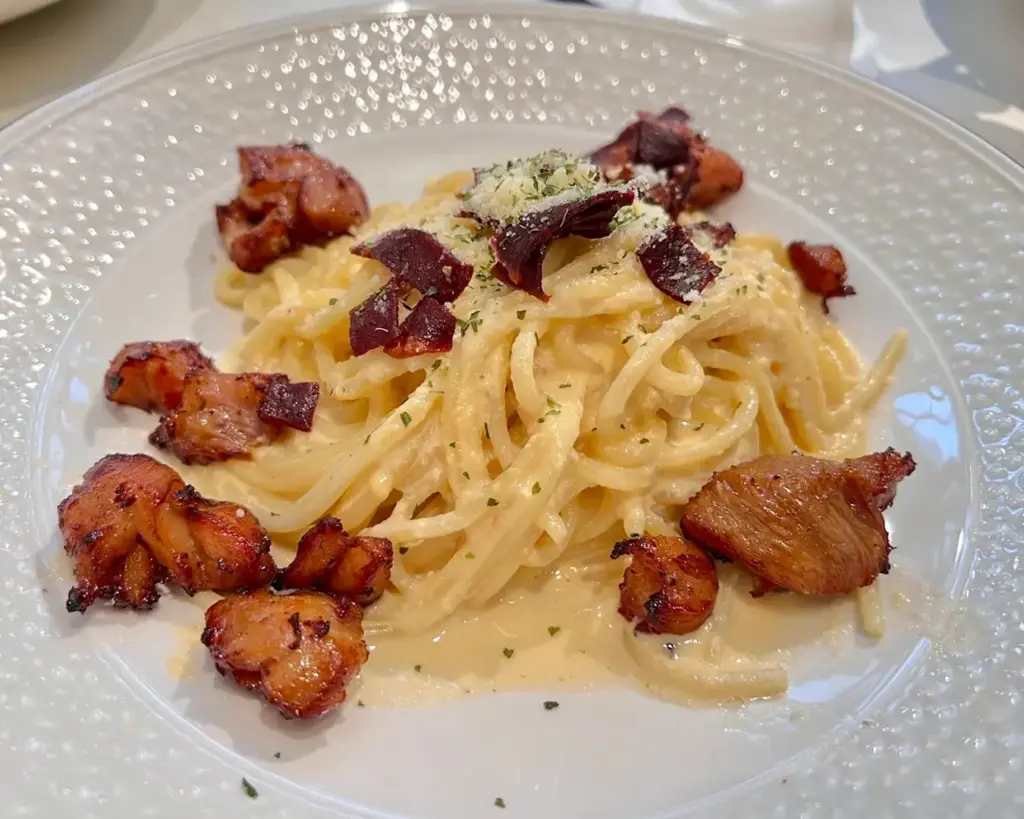 A creamy plate of spaghetti carbonara served at Mamma Mia Trattoria E Caffè, featuring pasta coated in rich egg-based sauce with crispy pancetta and grated cheese.