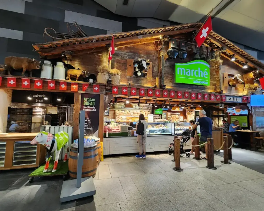 Front view of a food shop inside 313@Somerset Orchard mall in Singapore, showcasing a modern storefront, menu displays, and customers browsing or ordering food in the bustling mall.